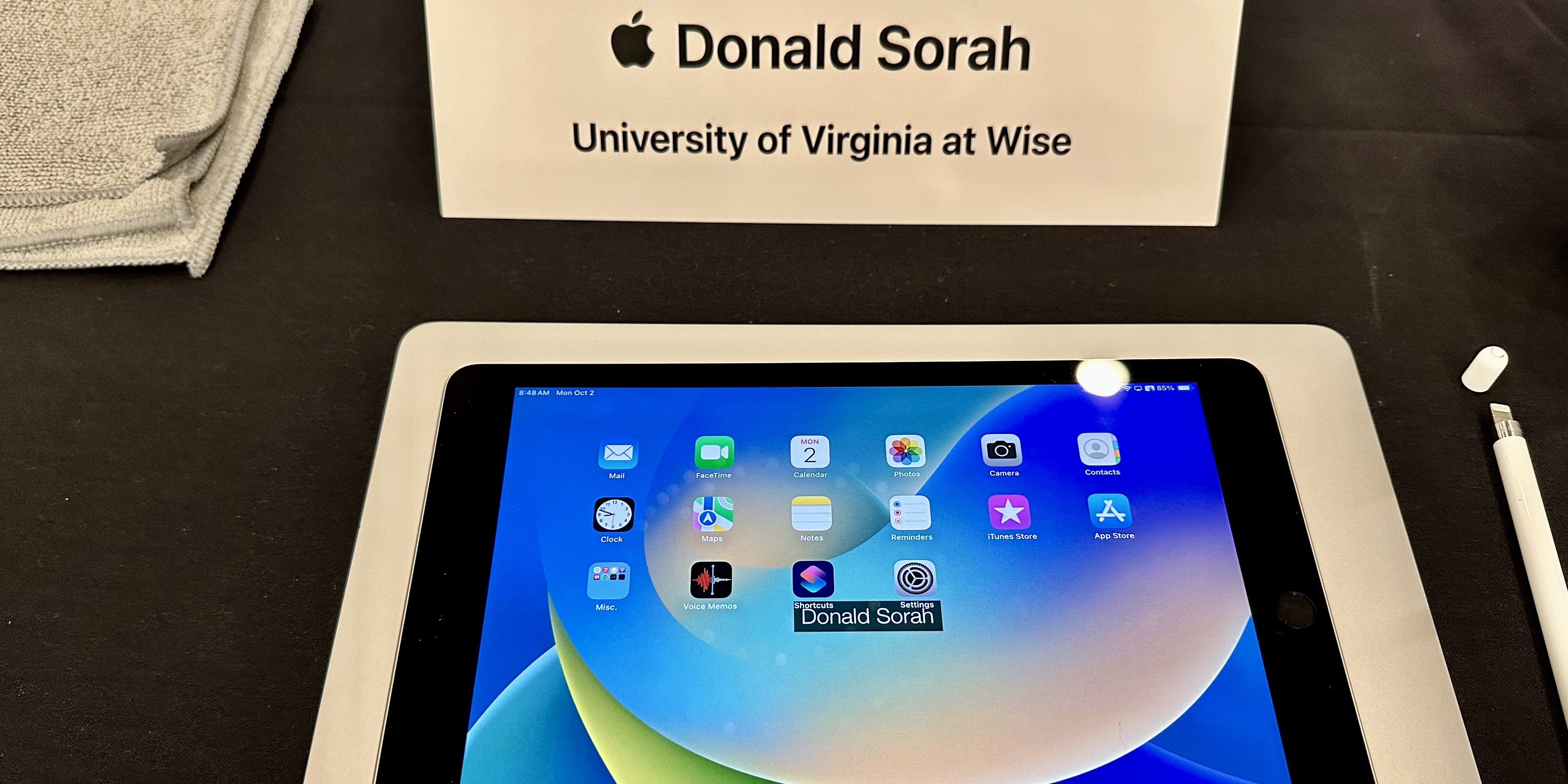 iPad on a desk with apps displayed on Home Screen.