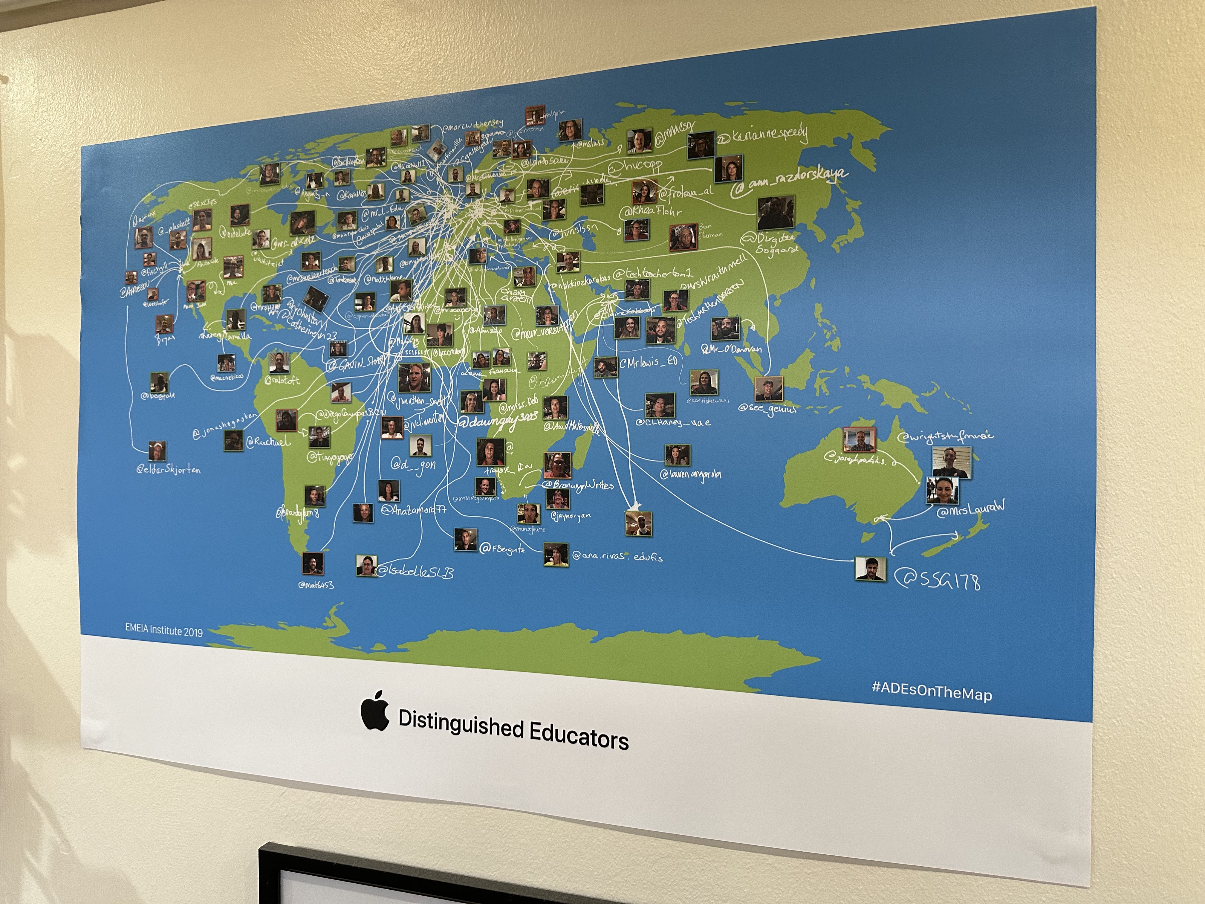 A photograph of a world map with hundreds of individual photos of ADE from around the world on it.
